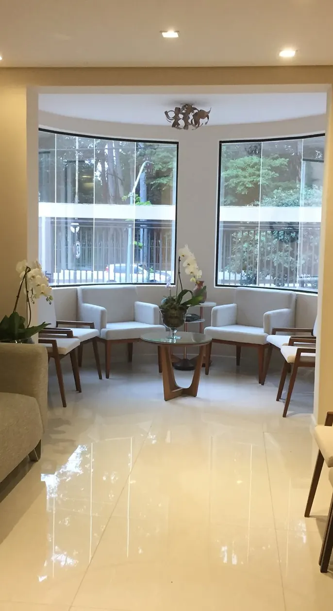 Sala de espera do consultório do Prof. Dr. Leandro Luongo de Matos, com poltronas e janelas amplas